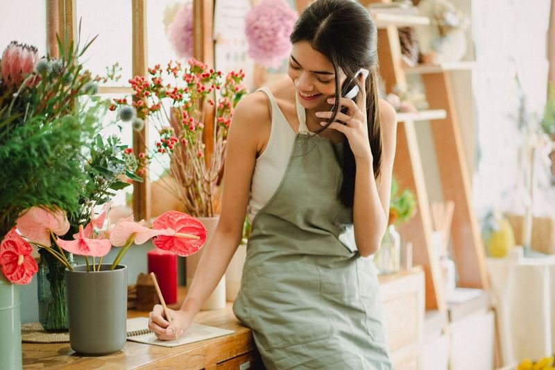 Shop owner taking an order on her phone