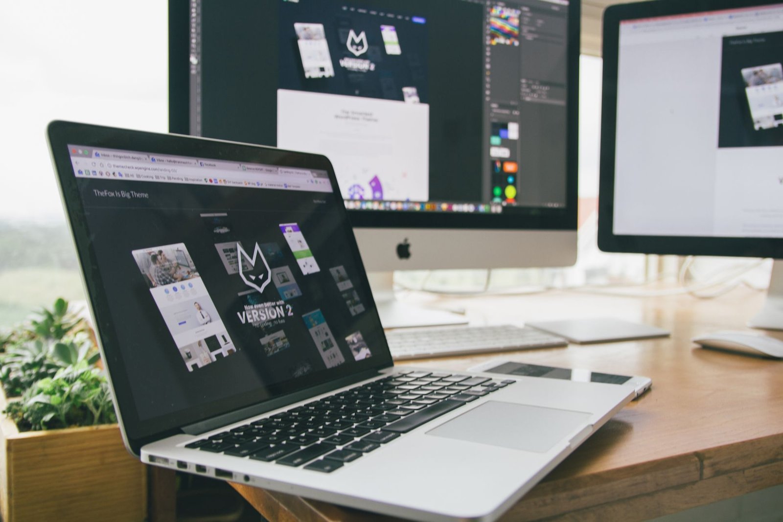 Website designs on a laptop and screens